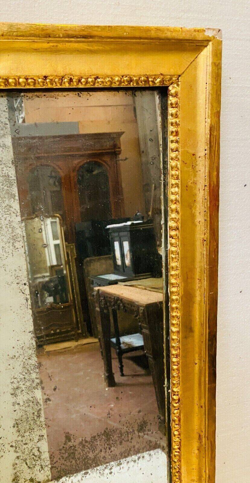 Louis XVI mirror in carved and gilded wood with leaf 18th century