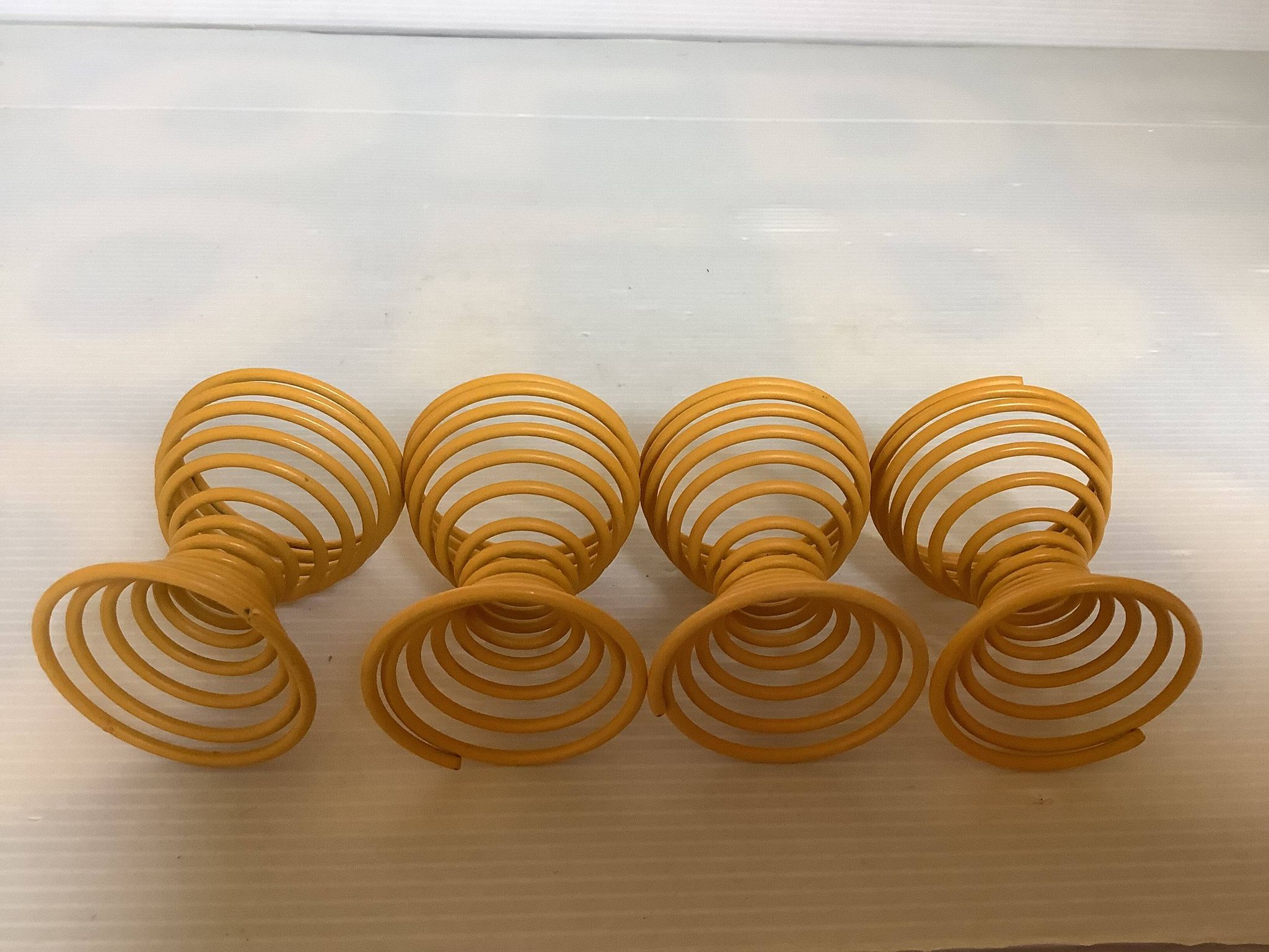 Four yellow spiral spring egg cups