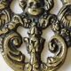 Decorative coat hook with cherubs/putti in aged brass.