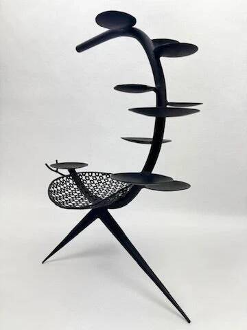 Candlestick sculpture in perforated iron clover motif