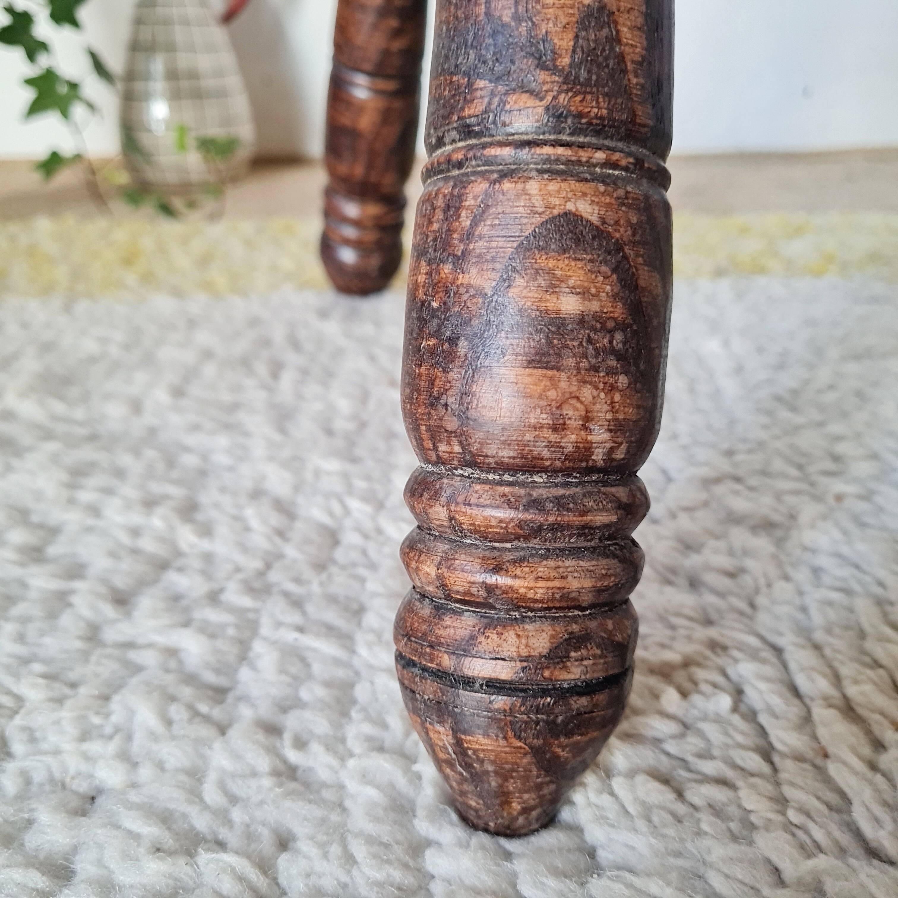 Small brutalist tripod stool made of turned wood.