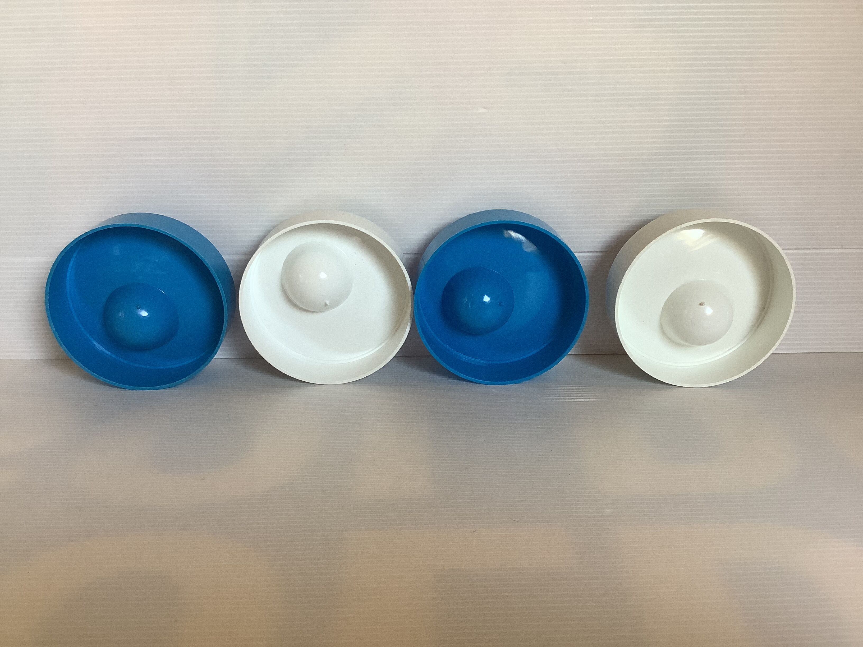Four round blue and white egg cups from the 1970s.