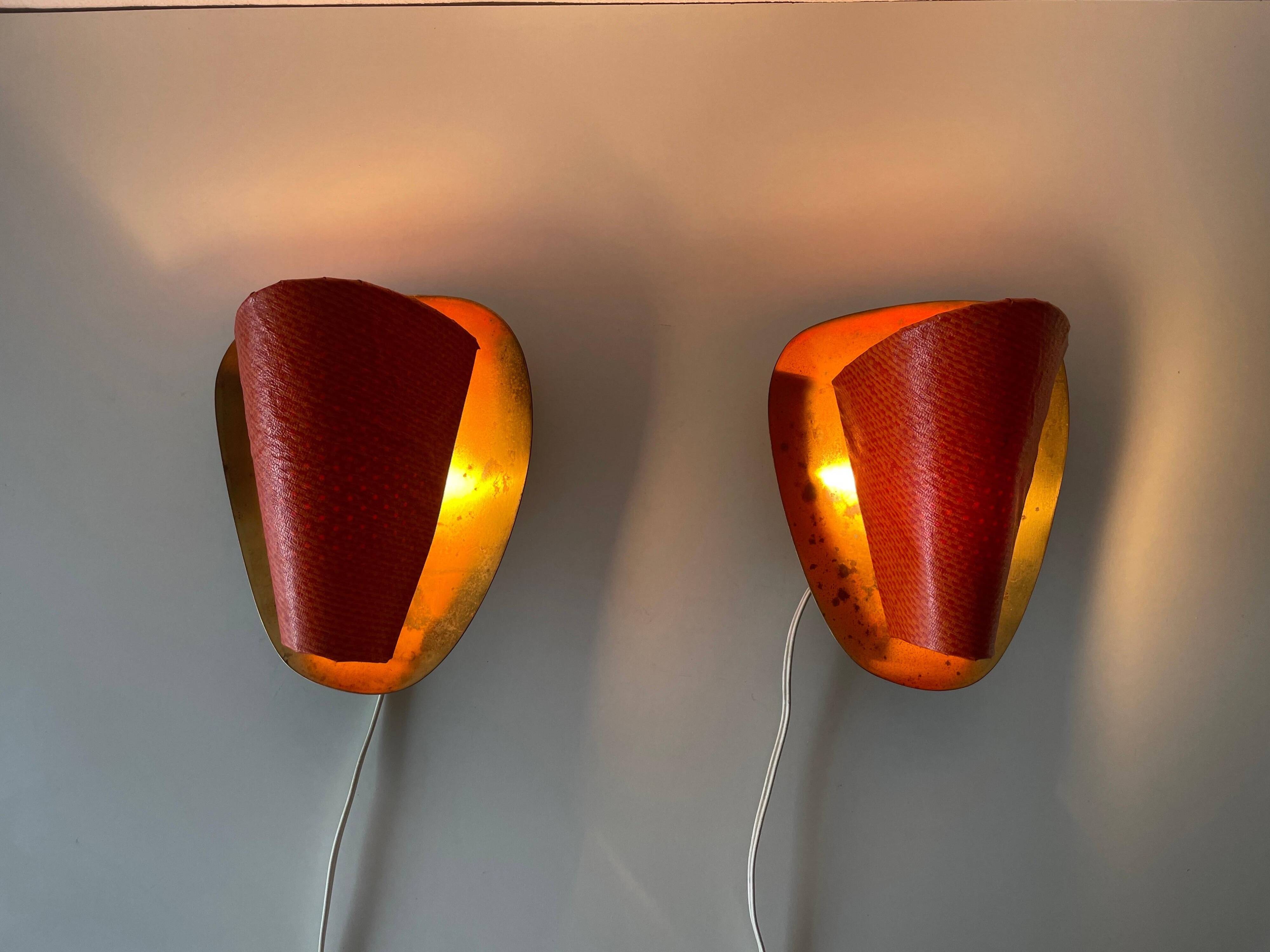 Pair of orange plexiglass and curved brass wall lights, 1950s, Germany