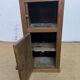 Old small storage unit with sliding and hinged doors.