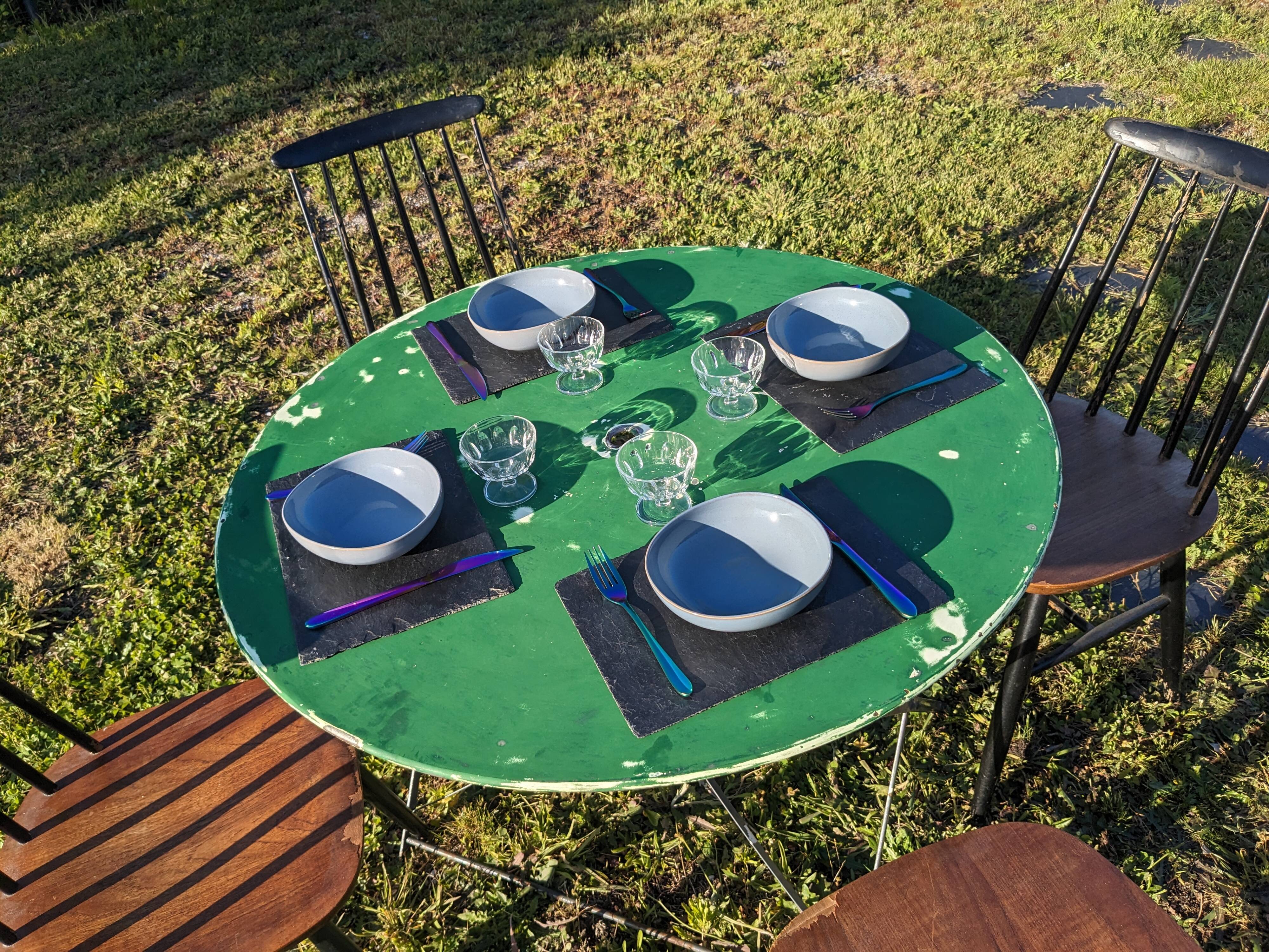 Antique round folding garden table with a green patina.