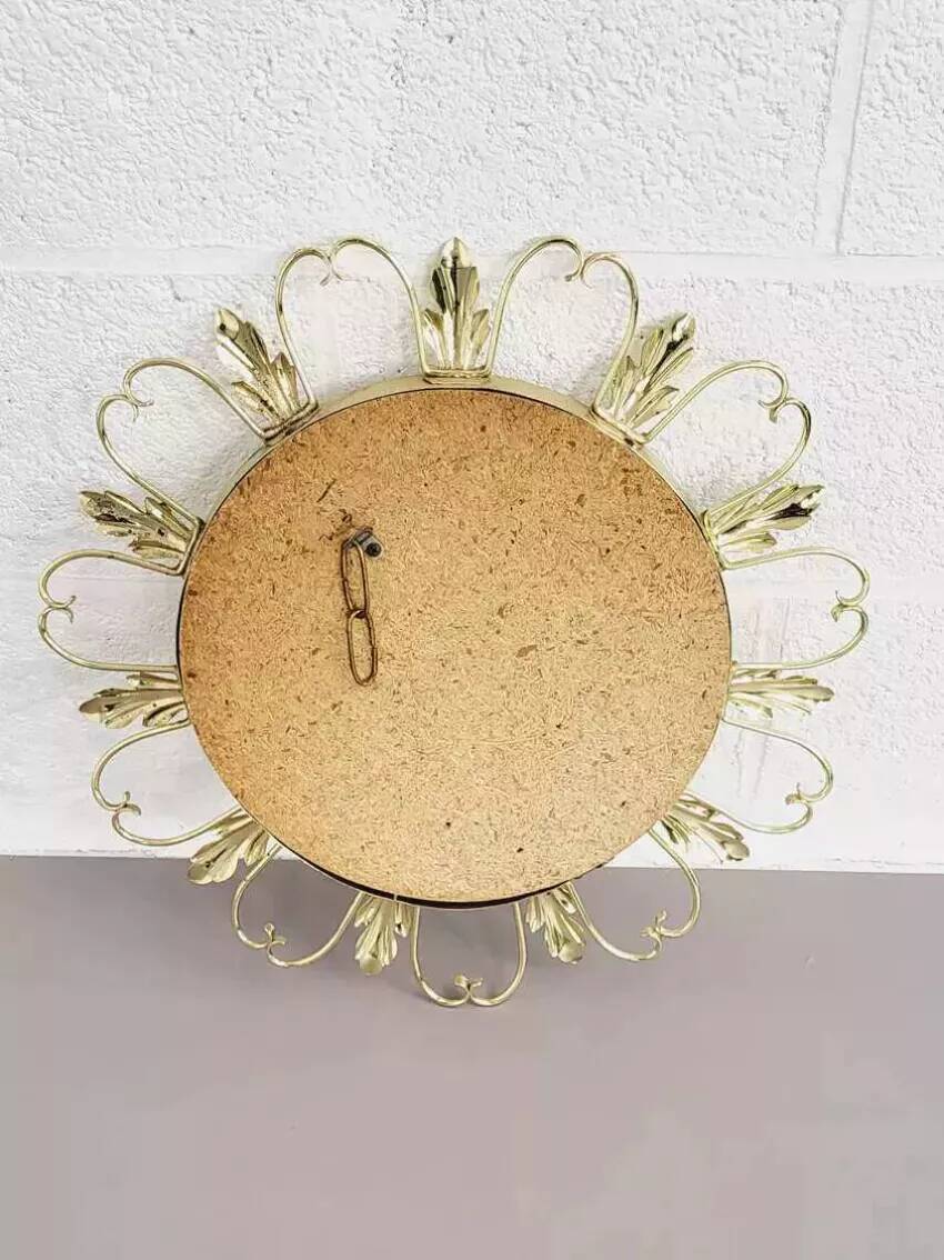 Round mirror on brass frame with scrolls