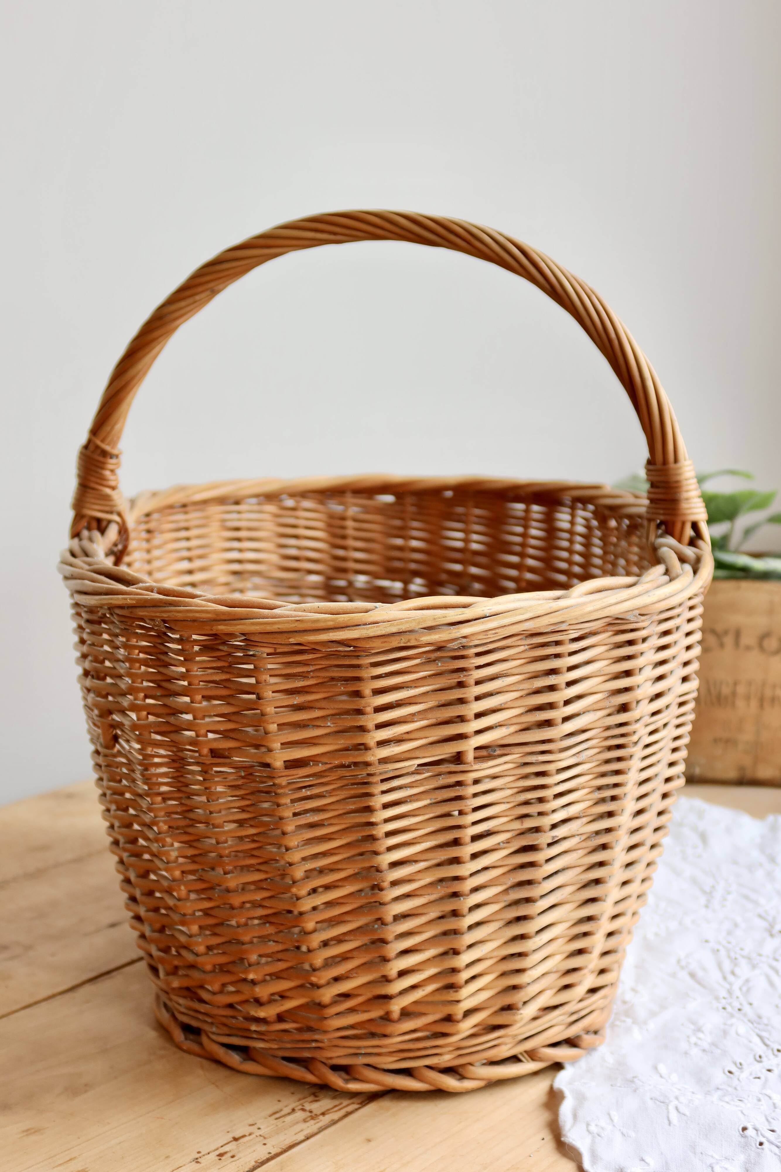 Large vintage woven wicker basket with a central handle.
