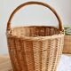 Large vintage woven wicker basket with a central handle.