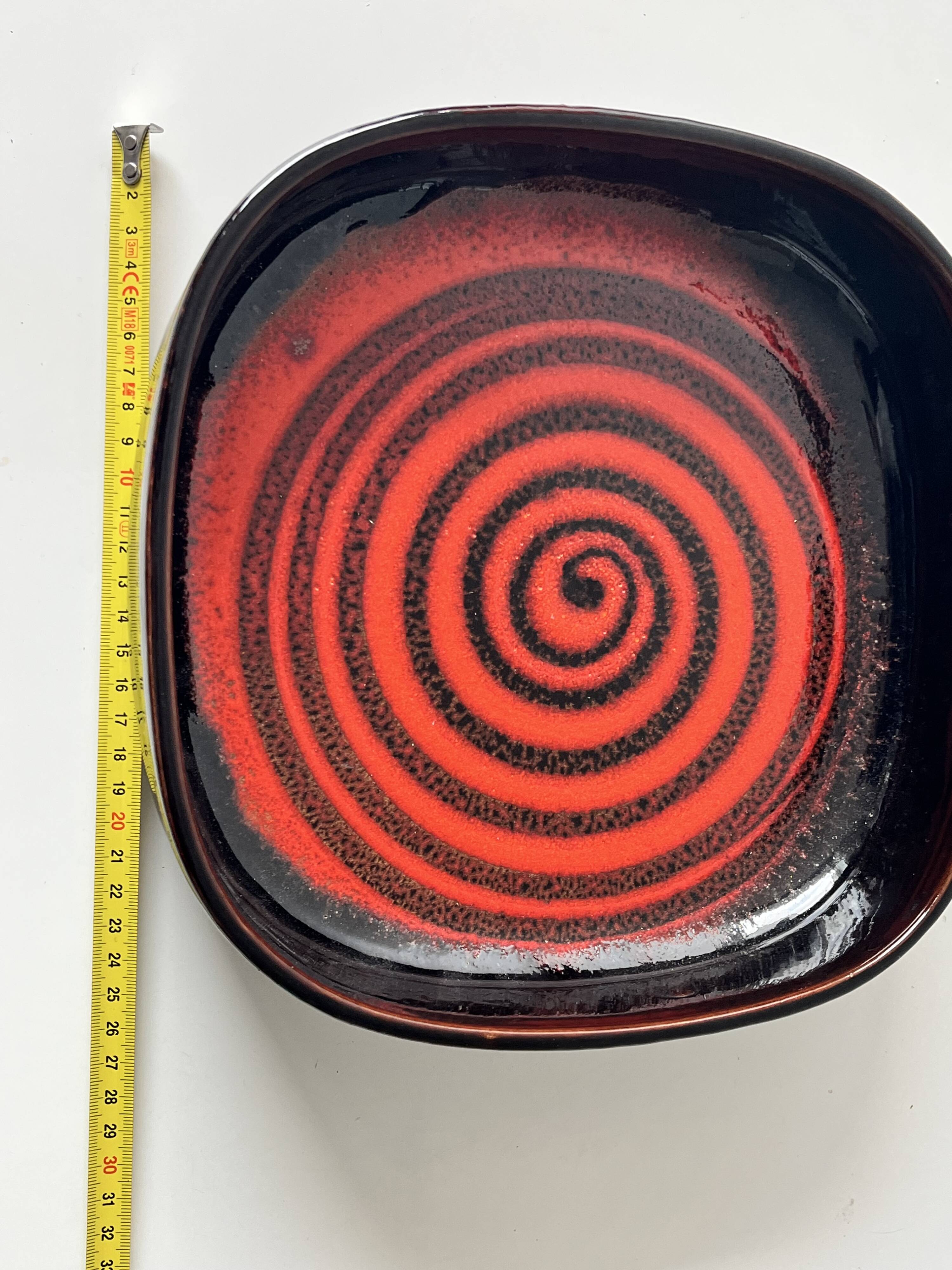 Large decorative ceramic catchall with red and black spiral pattern.