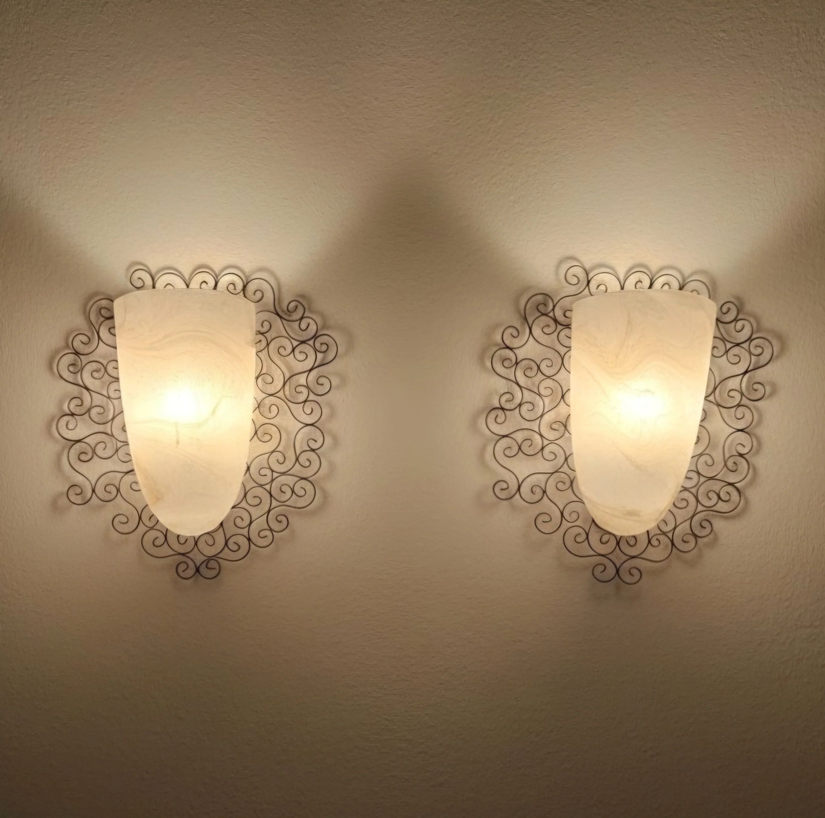 Wrought iron pocket wall sconces featuring a frosted amber glass / metal frame