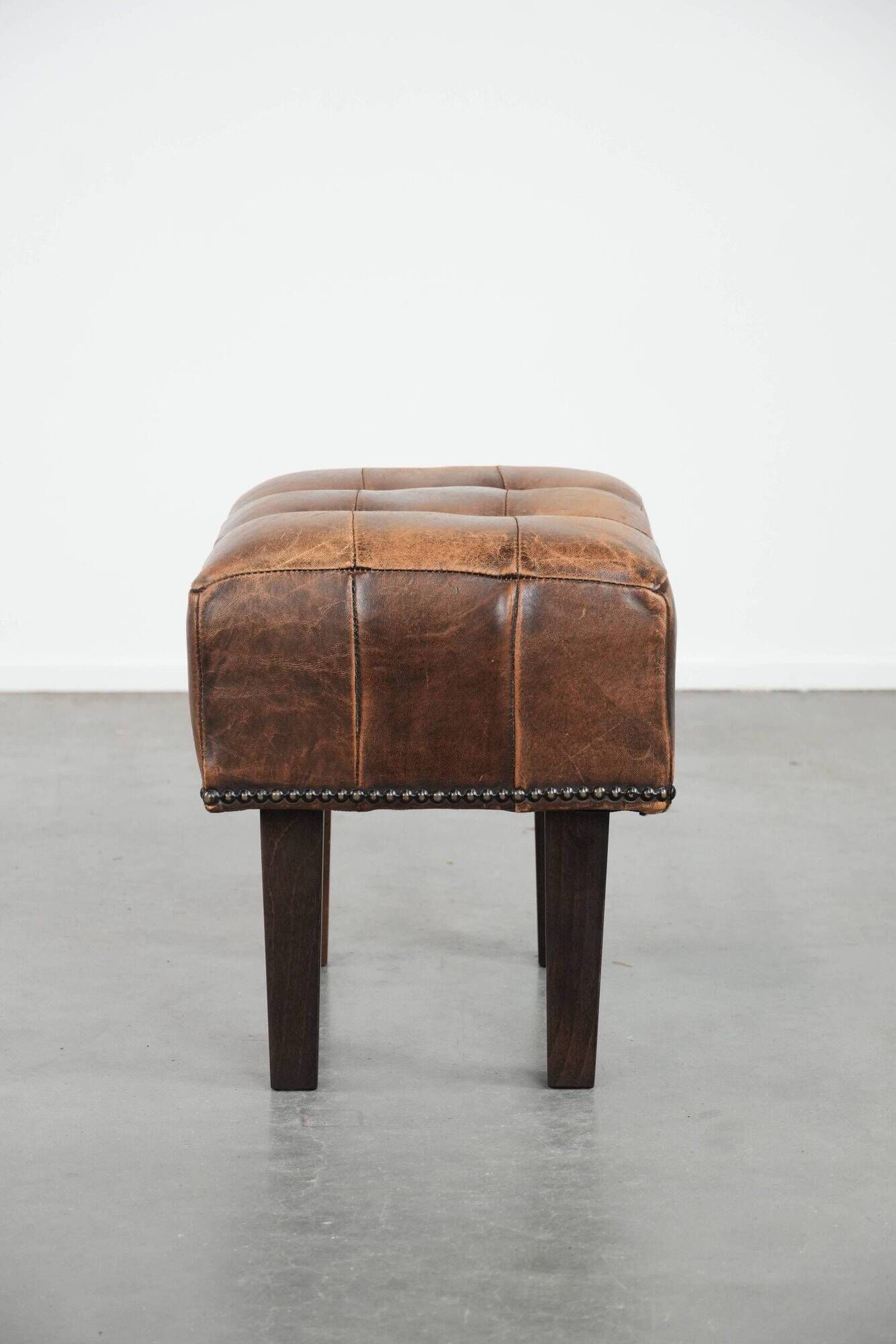 Beautiful sheepskin ottoman on high legs and beautiful warm colours