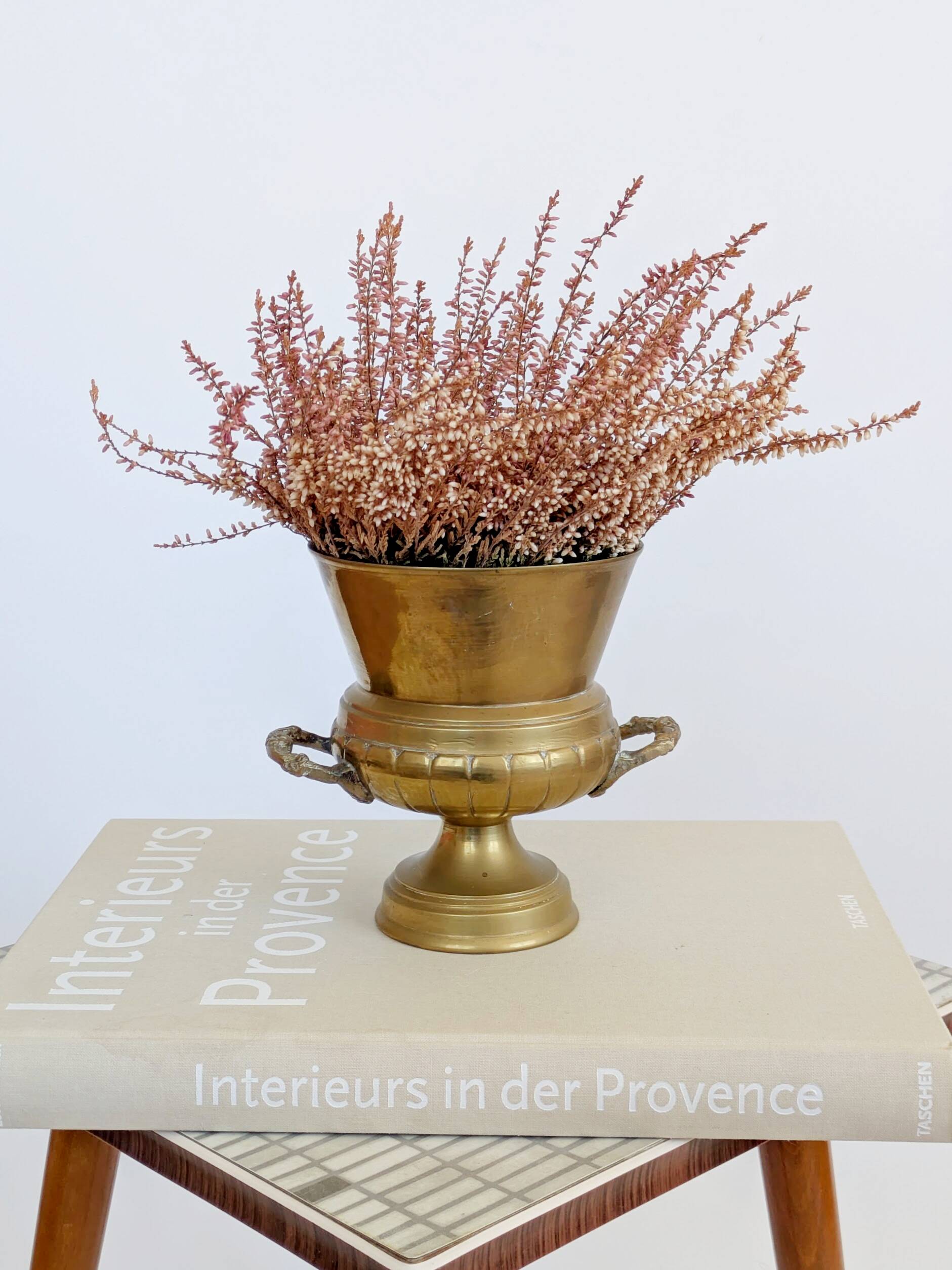 Vintage brass cache-pot on a stand with handles, classic decor.