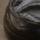 Vintage black leather pouf/ottoman with a rounded shape, French mid 20th Century.