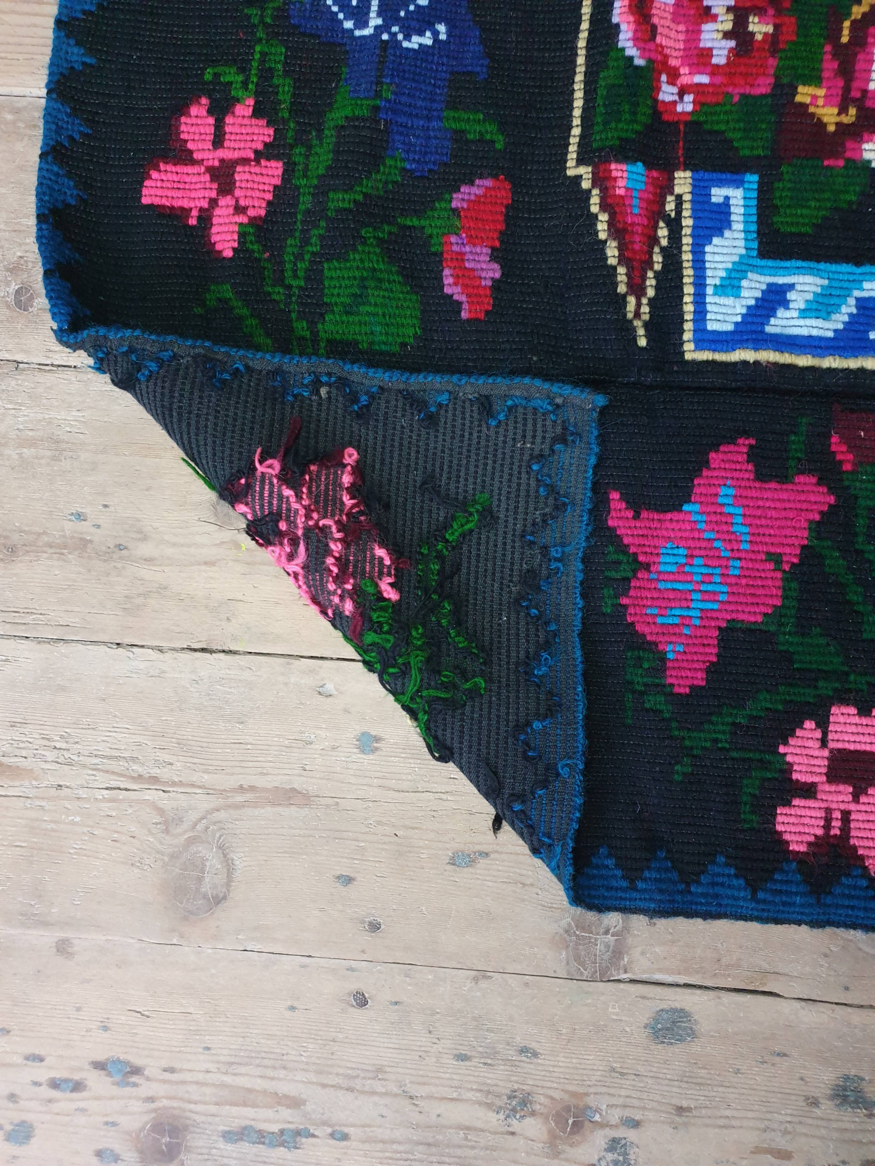 Handwoven floral wool rug, black background with pink roses and geometric design 207x144cm