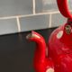 Red enameled sheet metal kettle with white polka dots
