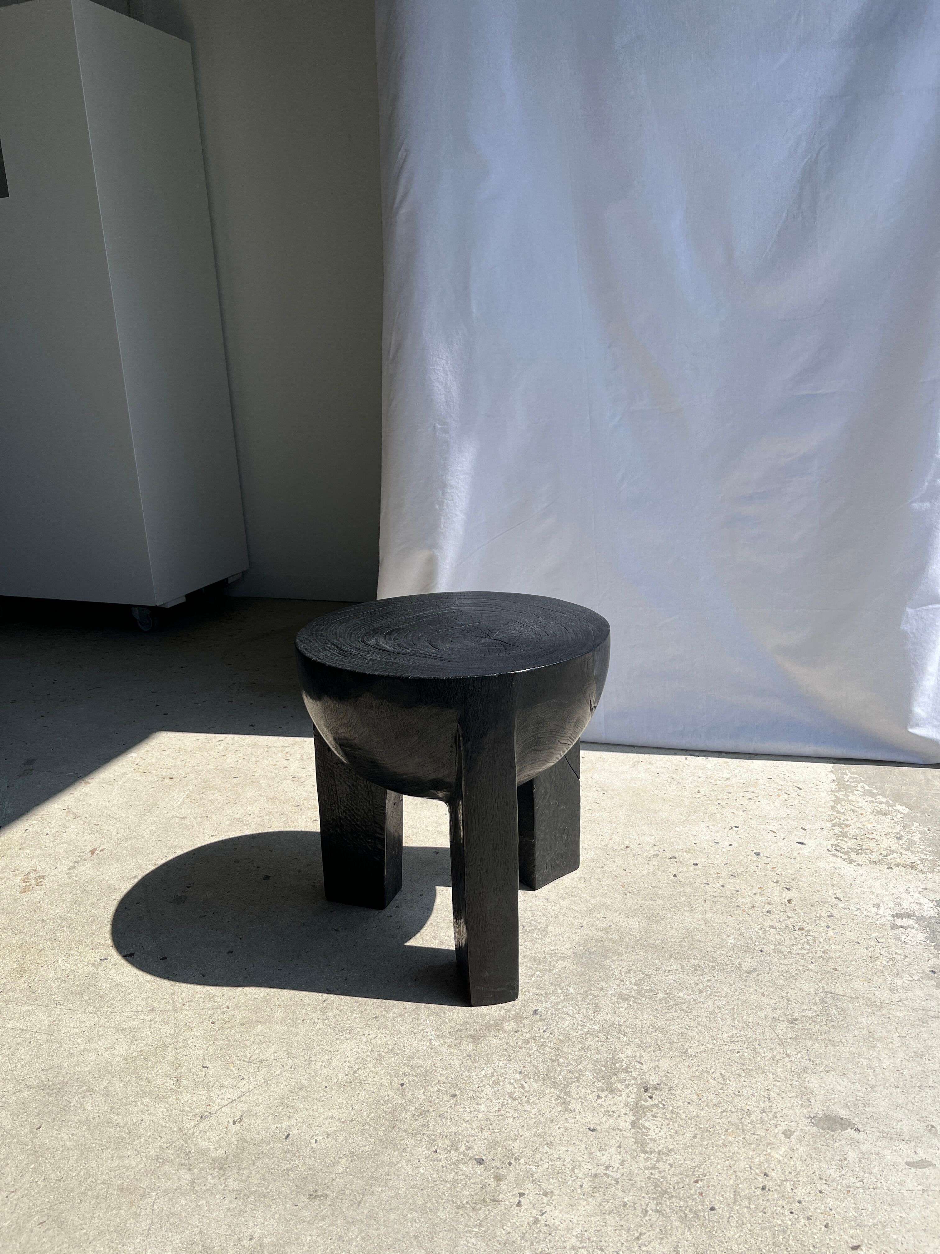 Black mango wood tripod side table with a semi-spherical top, height: 45 cm, diameter: 44 cm.
