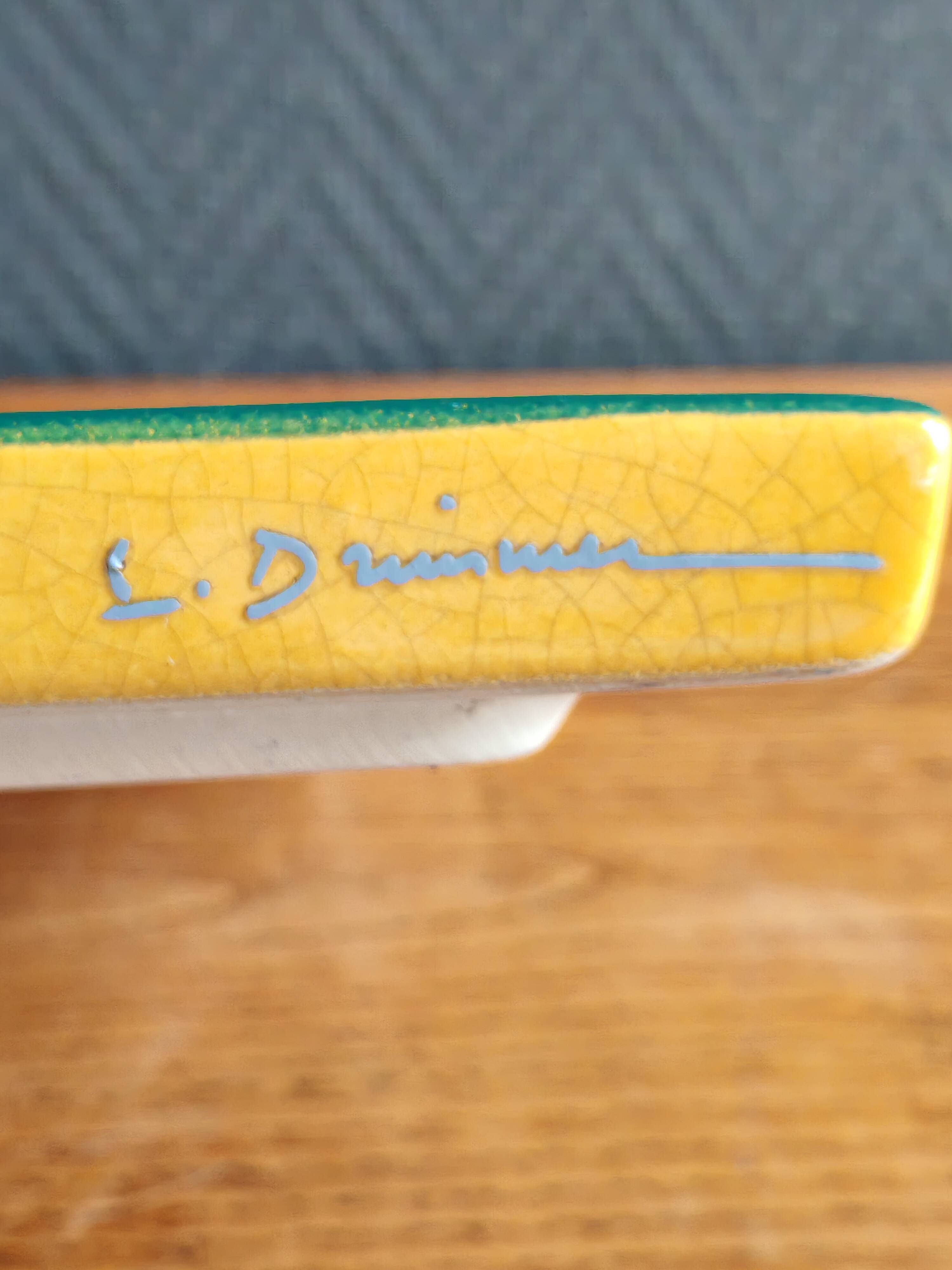 Yellow glazed ceramic trivet signed l. drimmer