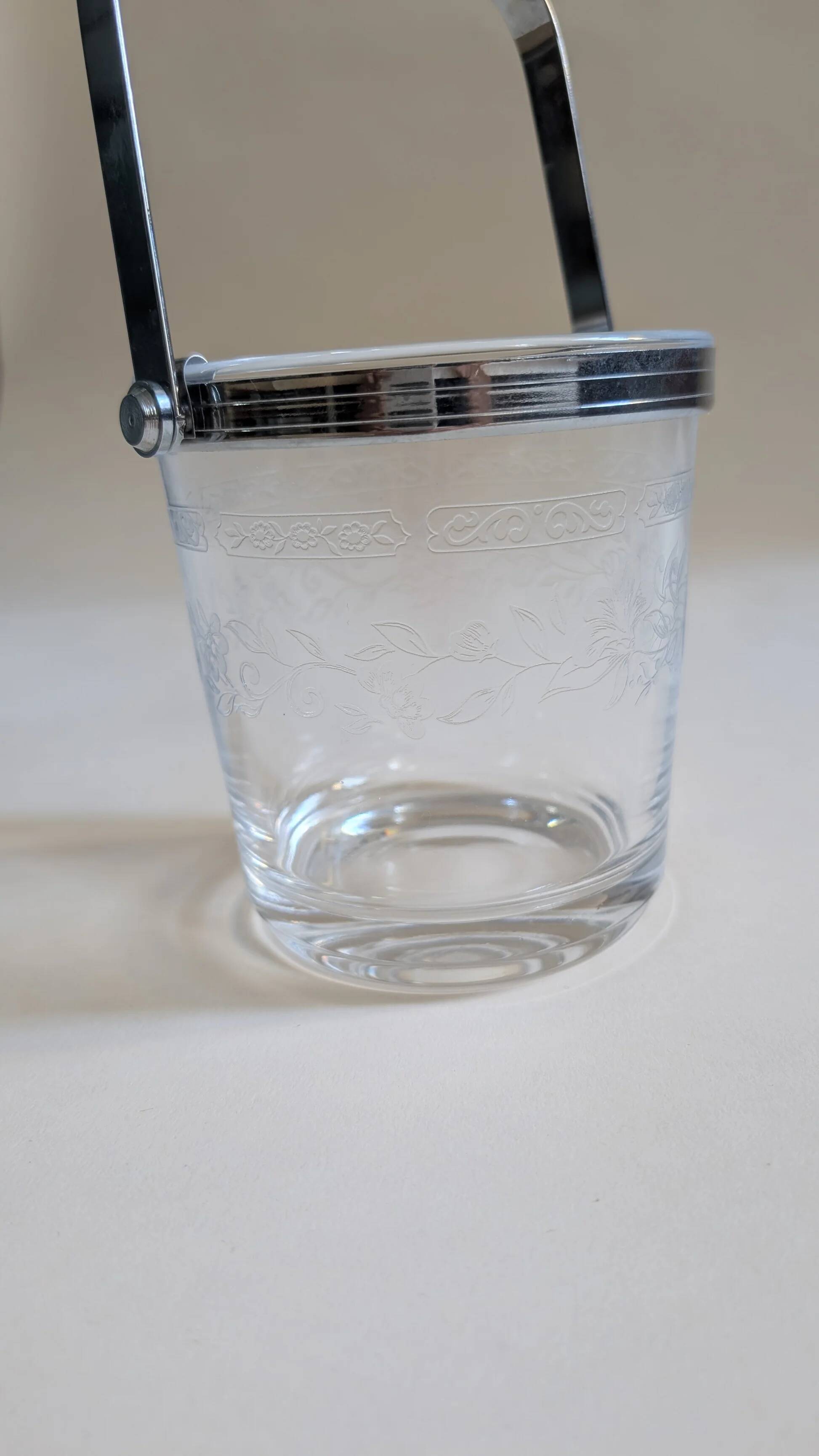 Clear glass ice bucket with an etched floral design