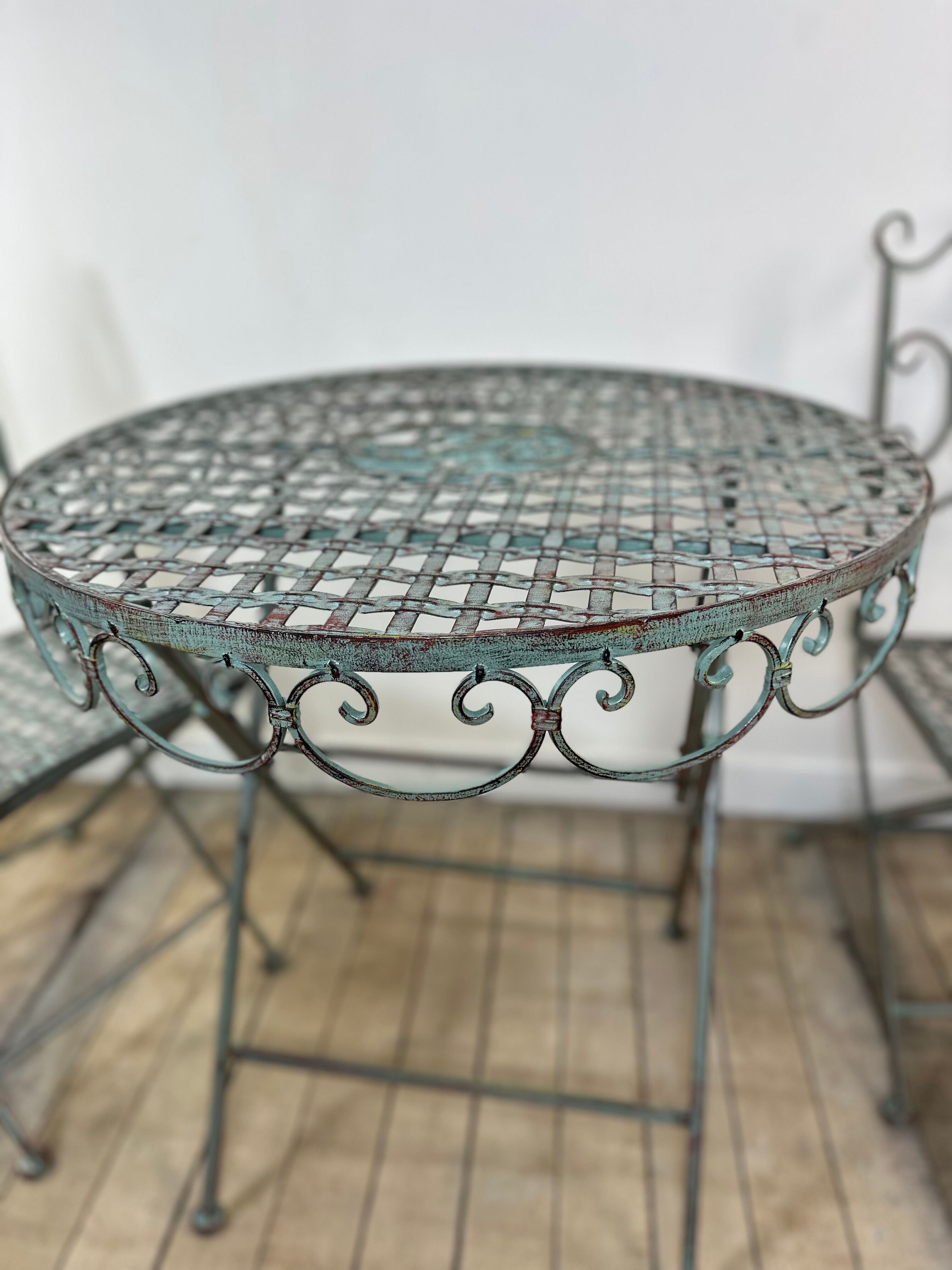 Patinated green folding wrought iron garden set with 1 table + 2 chairs.
