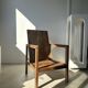 Large armchair in natural wood (teak) with a minimalist design.