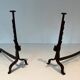 Pair of wrought iron andirons with adjustable supports and tripod feet.