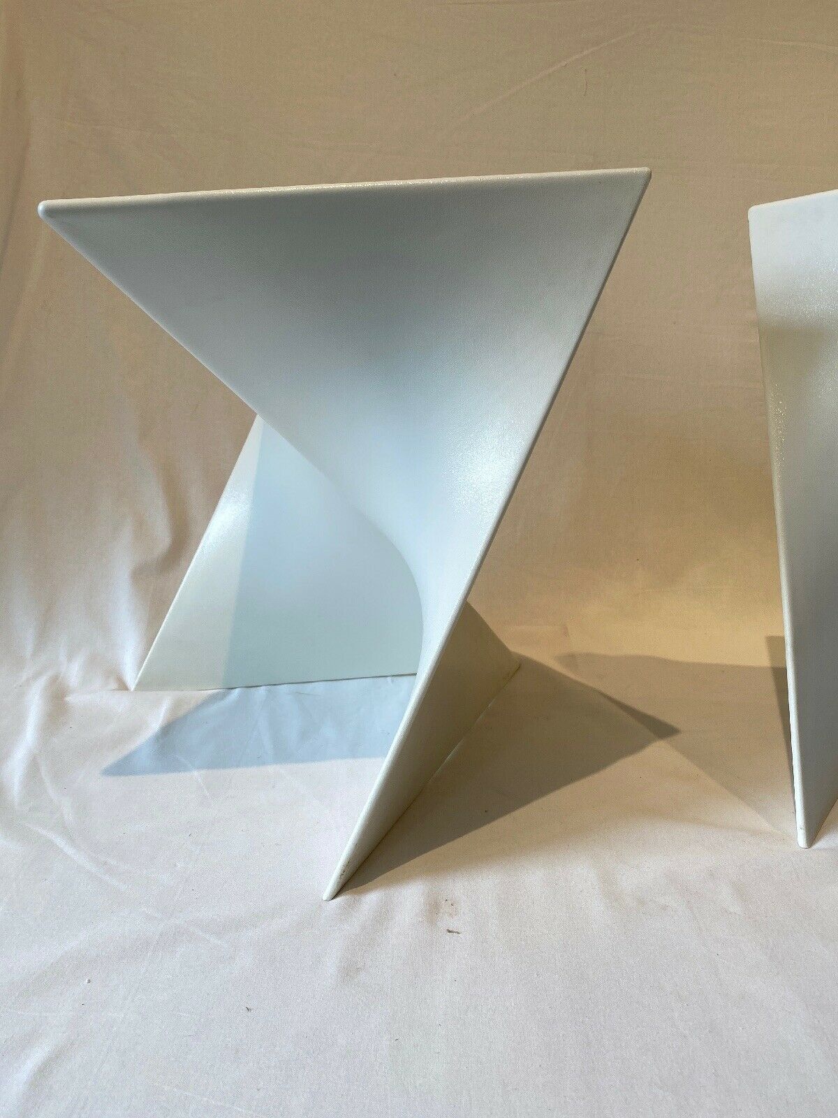 Pair of unmarked triangular white design stools
