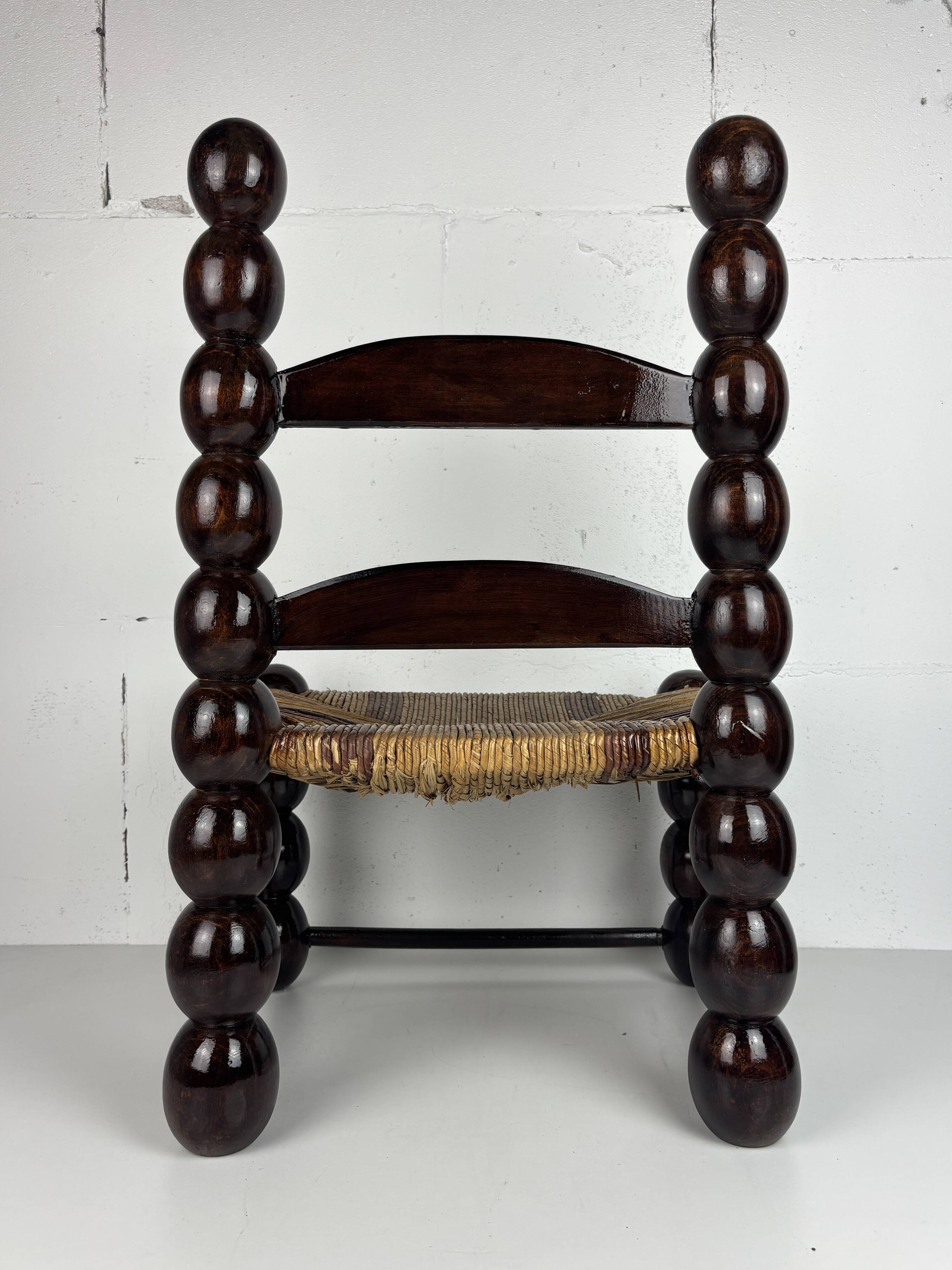 Brutalist wood turned bobbin low rush chair n the style of Charles Dudouyt