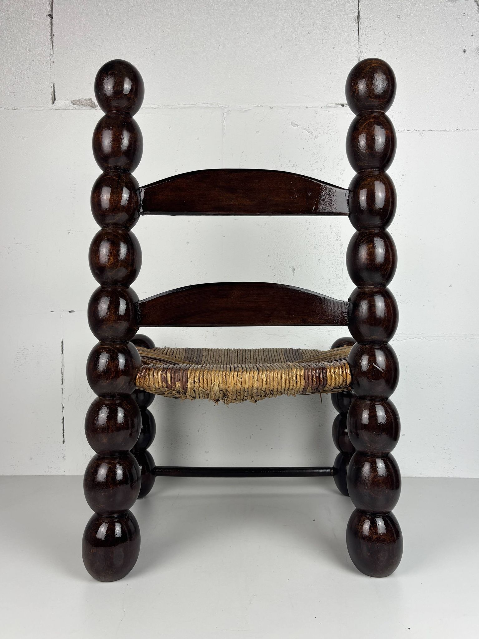 Brutalist wood turned bobbin low rush chair n the style of Charles Dudouyt