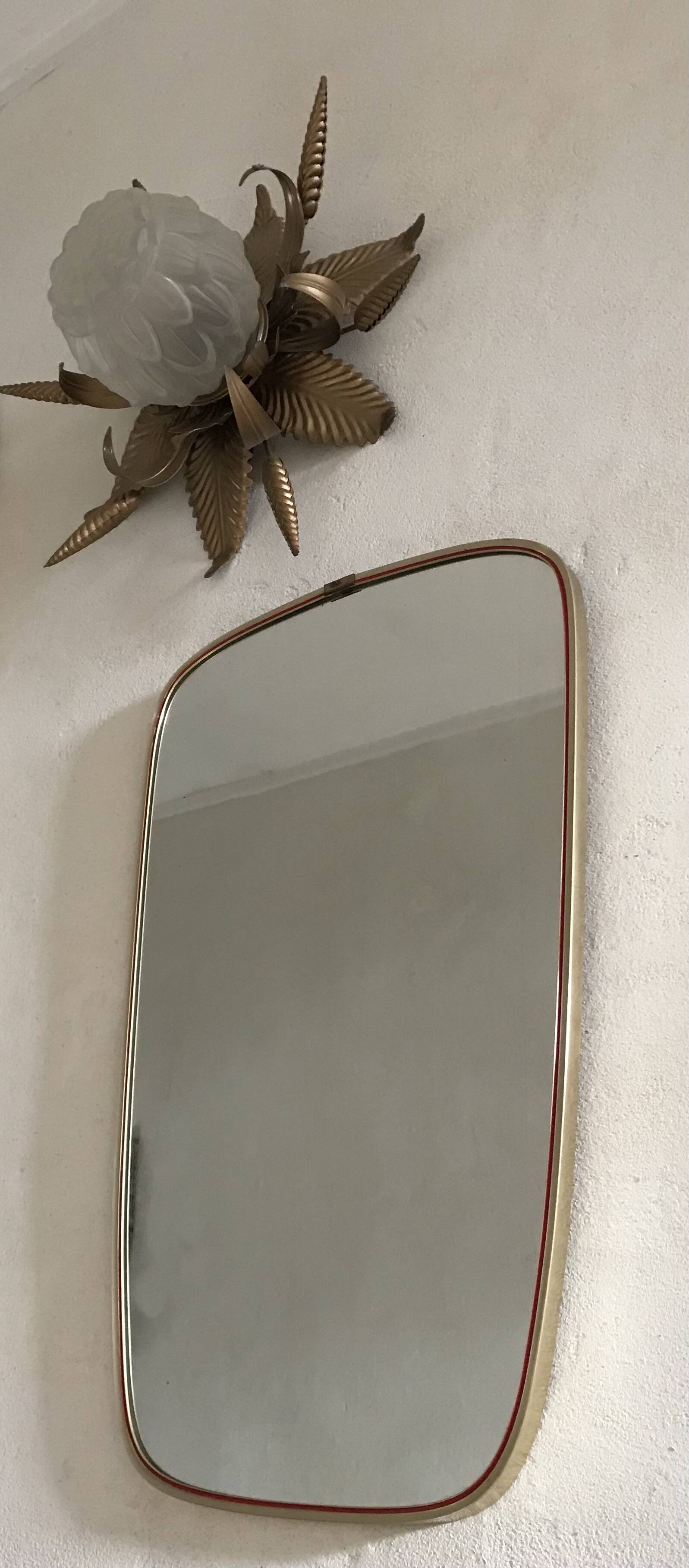 Vintage 1960s mirror in a freeform shape with a gold and red trim.