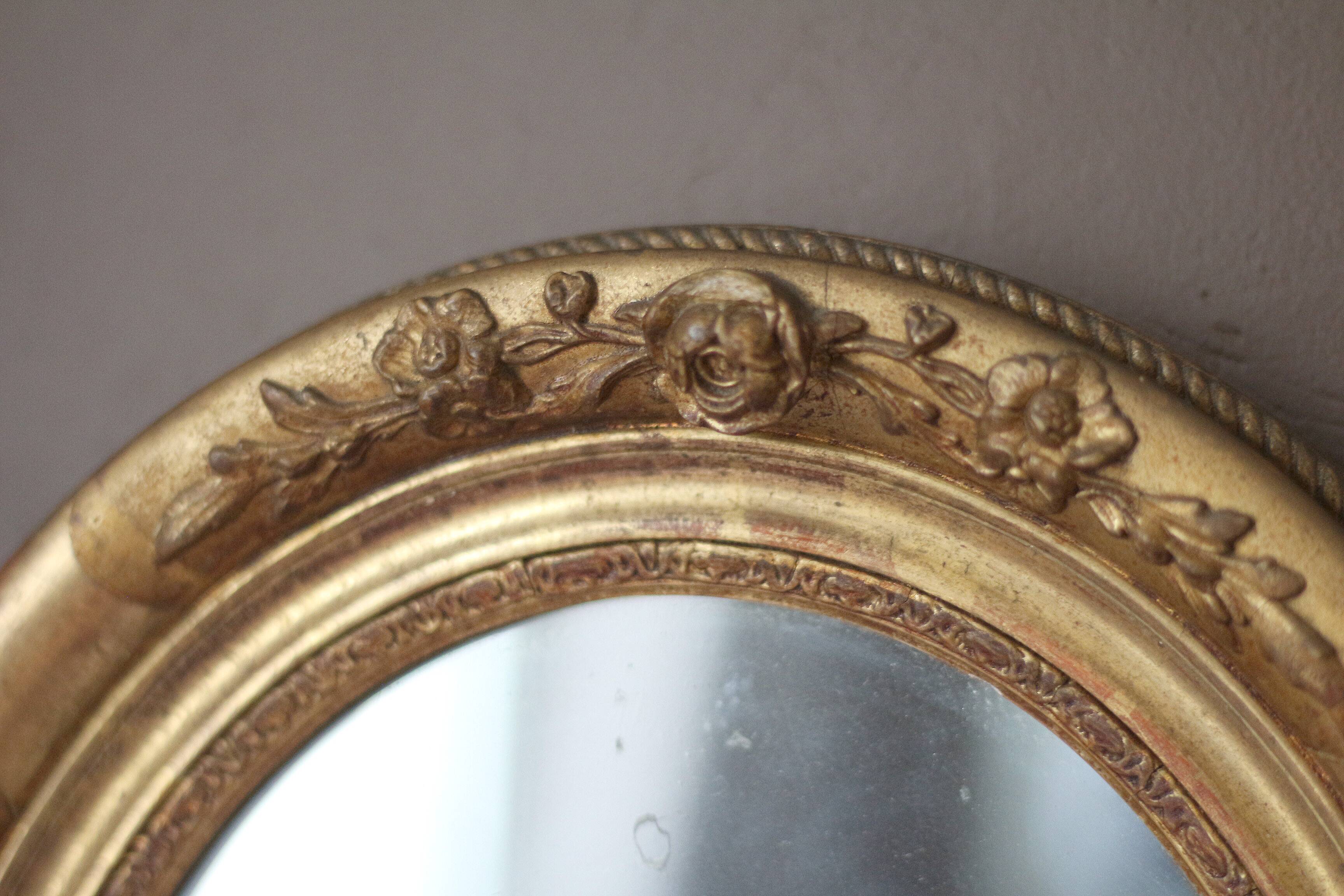 Oval wall mirror with gilded frame and mercury glass. Late 19th-early 20th century.