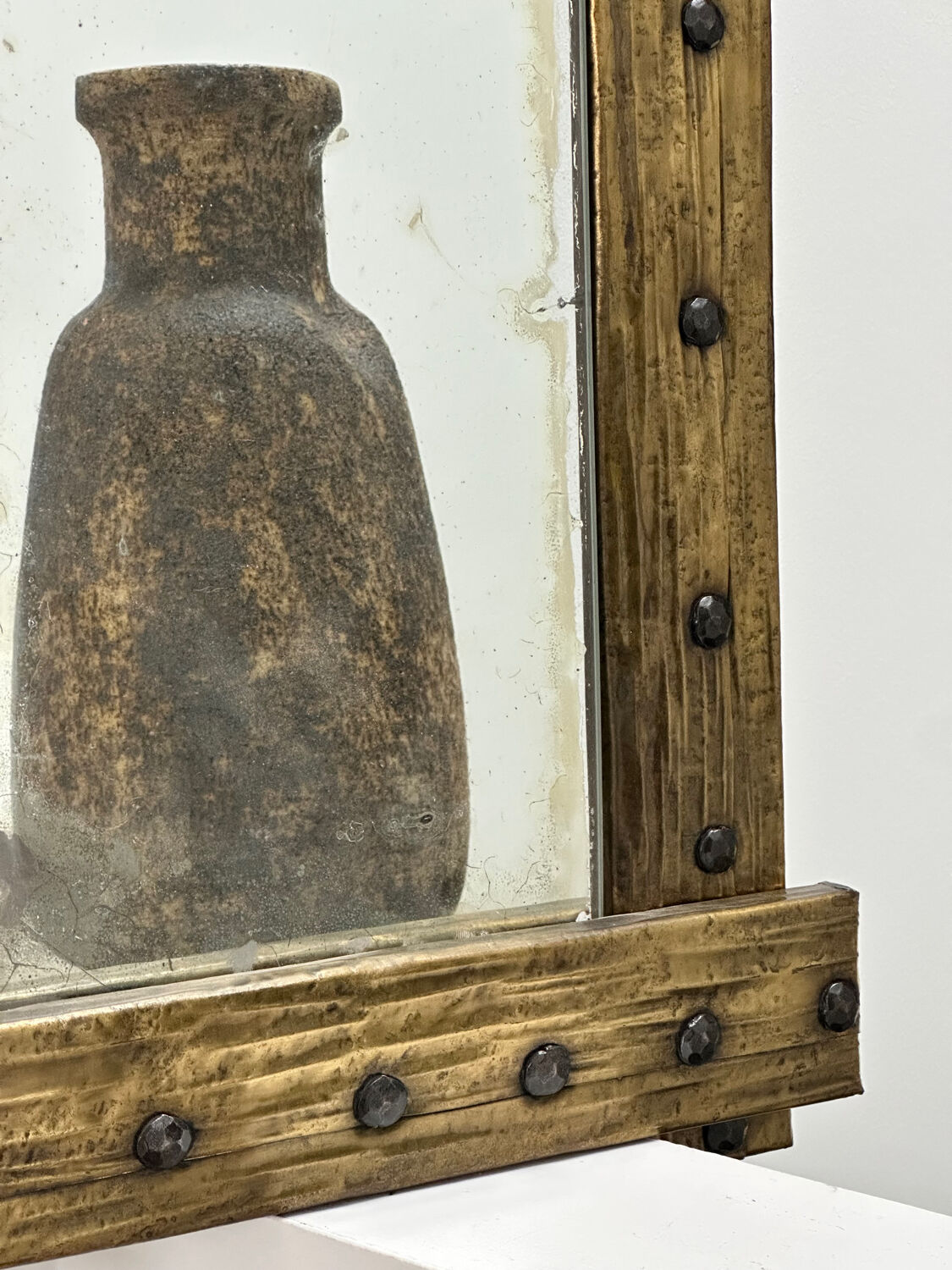 Brutalist mirror with a hammered copper and brass frame.