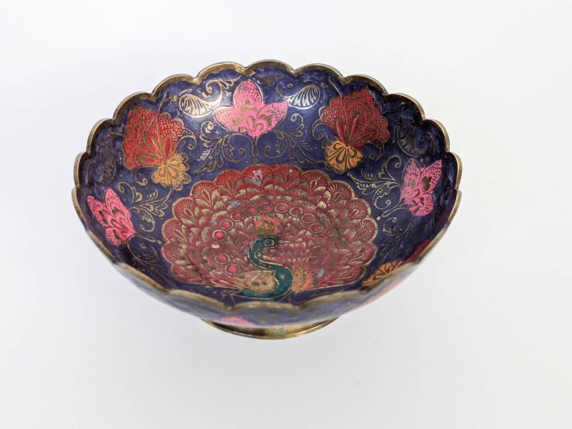Vintage brass bowl with peacock motif, painted enamel, scalloped edge on a pedestal.
