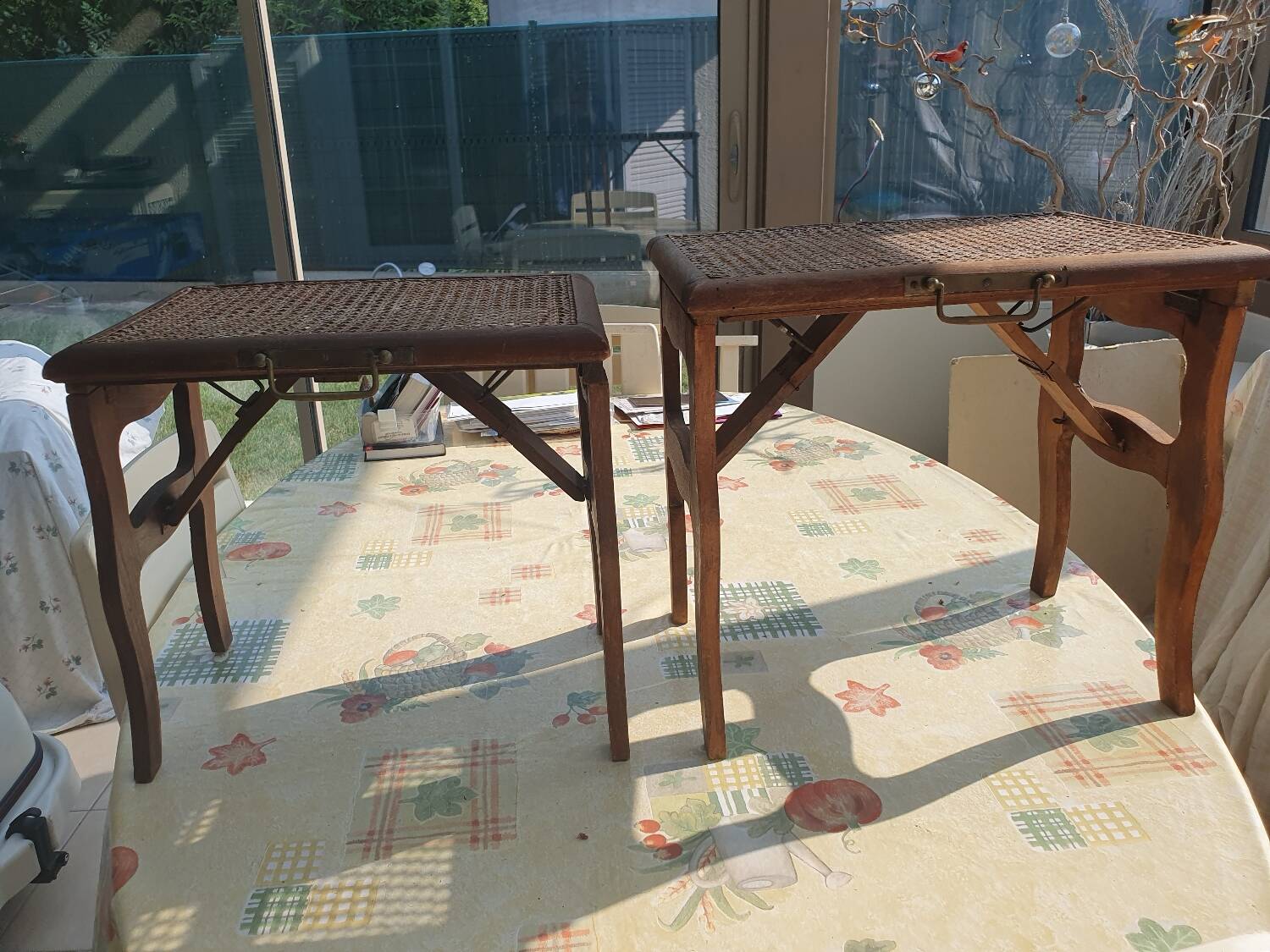 Two folding stools with caned seats.