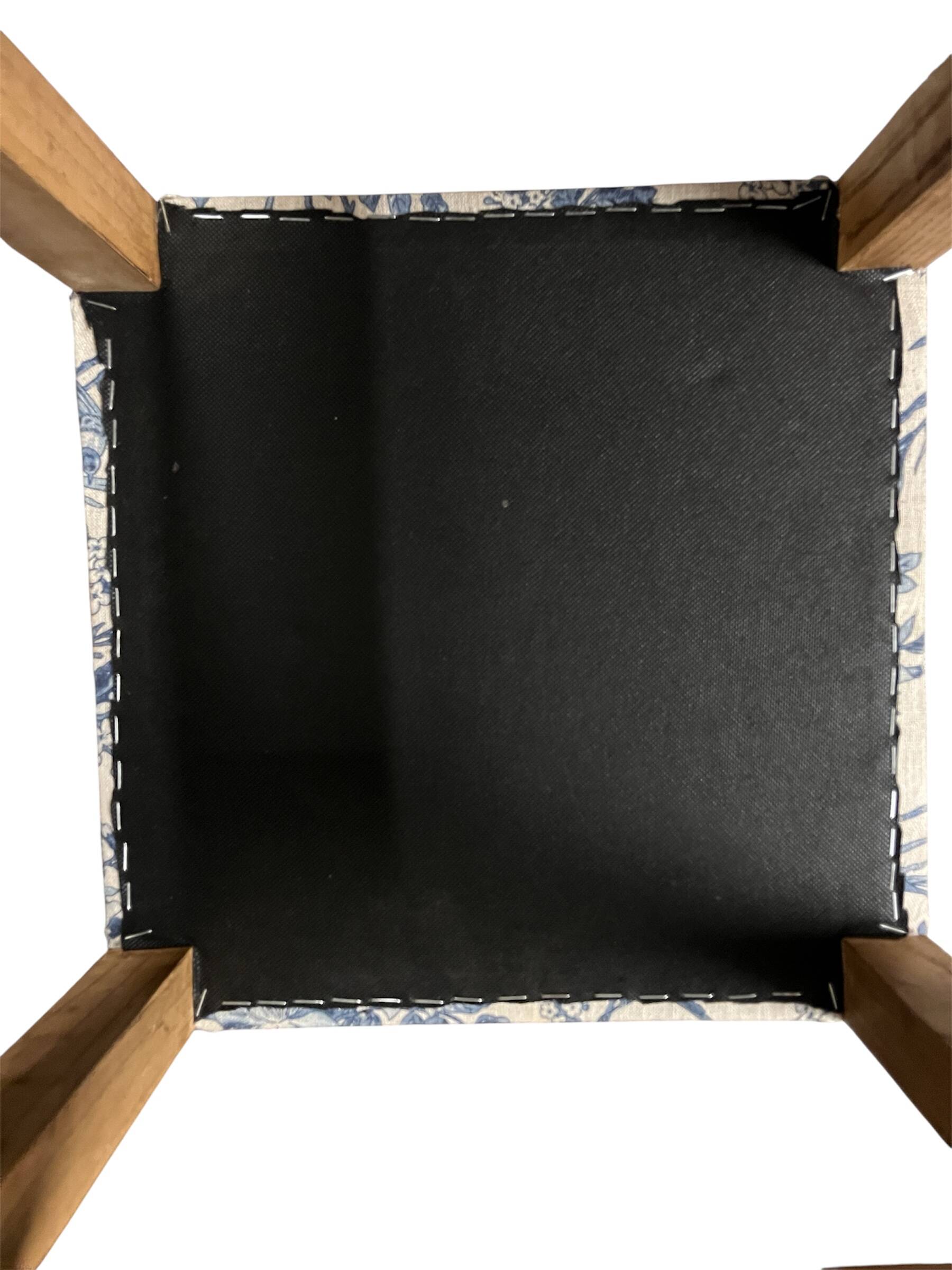 Square pouf with a checkered pattern.