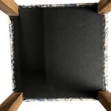 Square pouf with a checkered pattern.