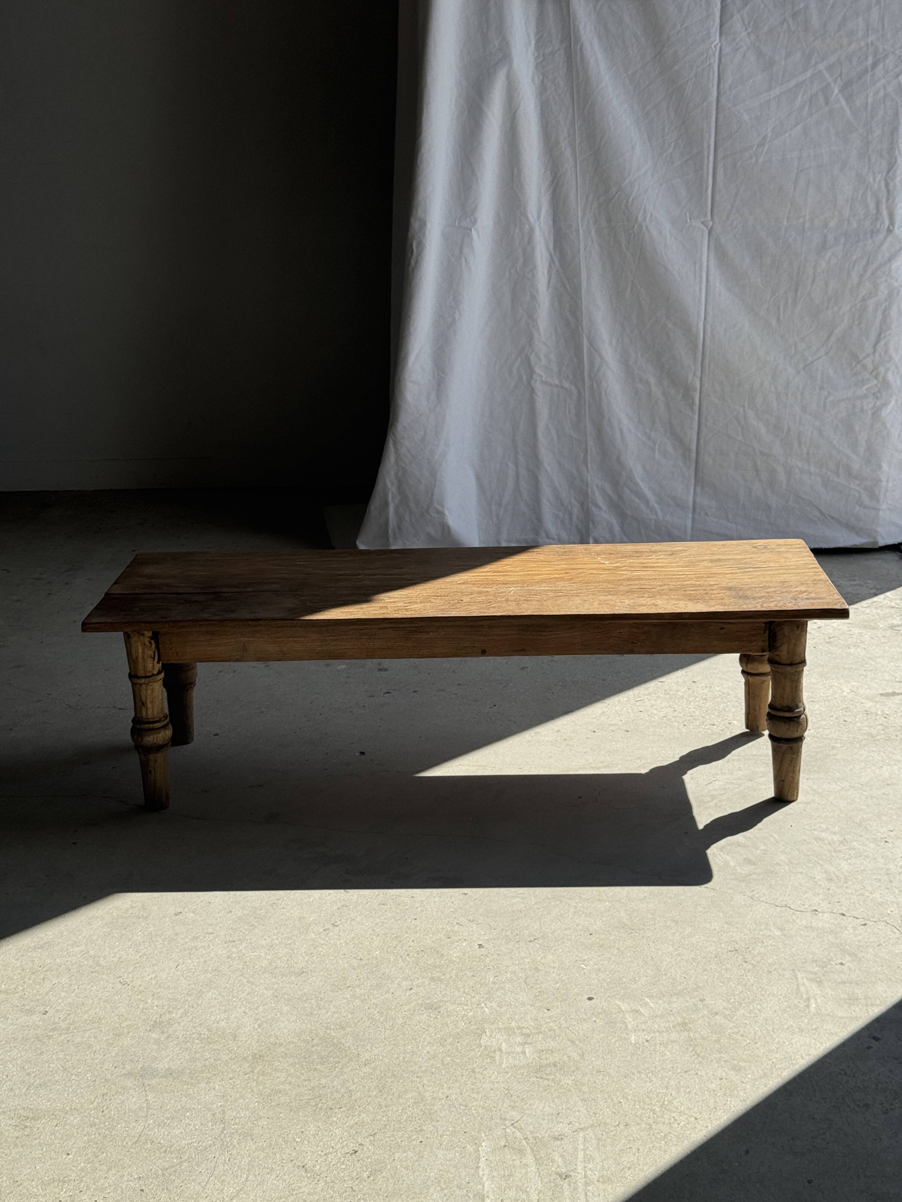 Brown Indonesian teak coffee table, with a border and cylindrical legs H40 L103.