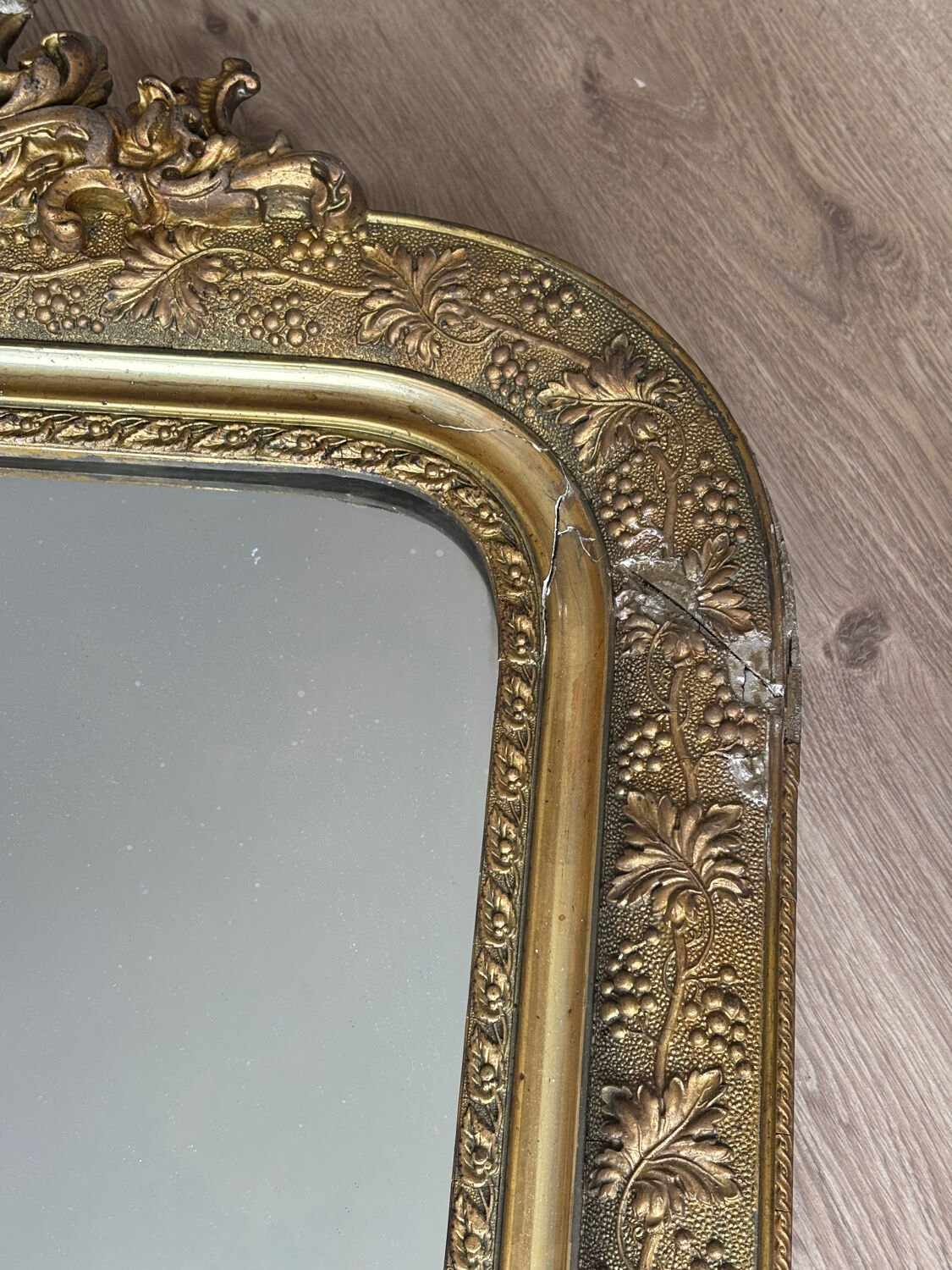 Golden mirror with a pediment from the early 20th century.