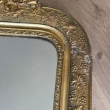 Golden mirror with a pediment from the early 20th century.