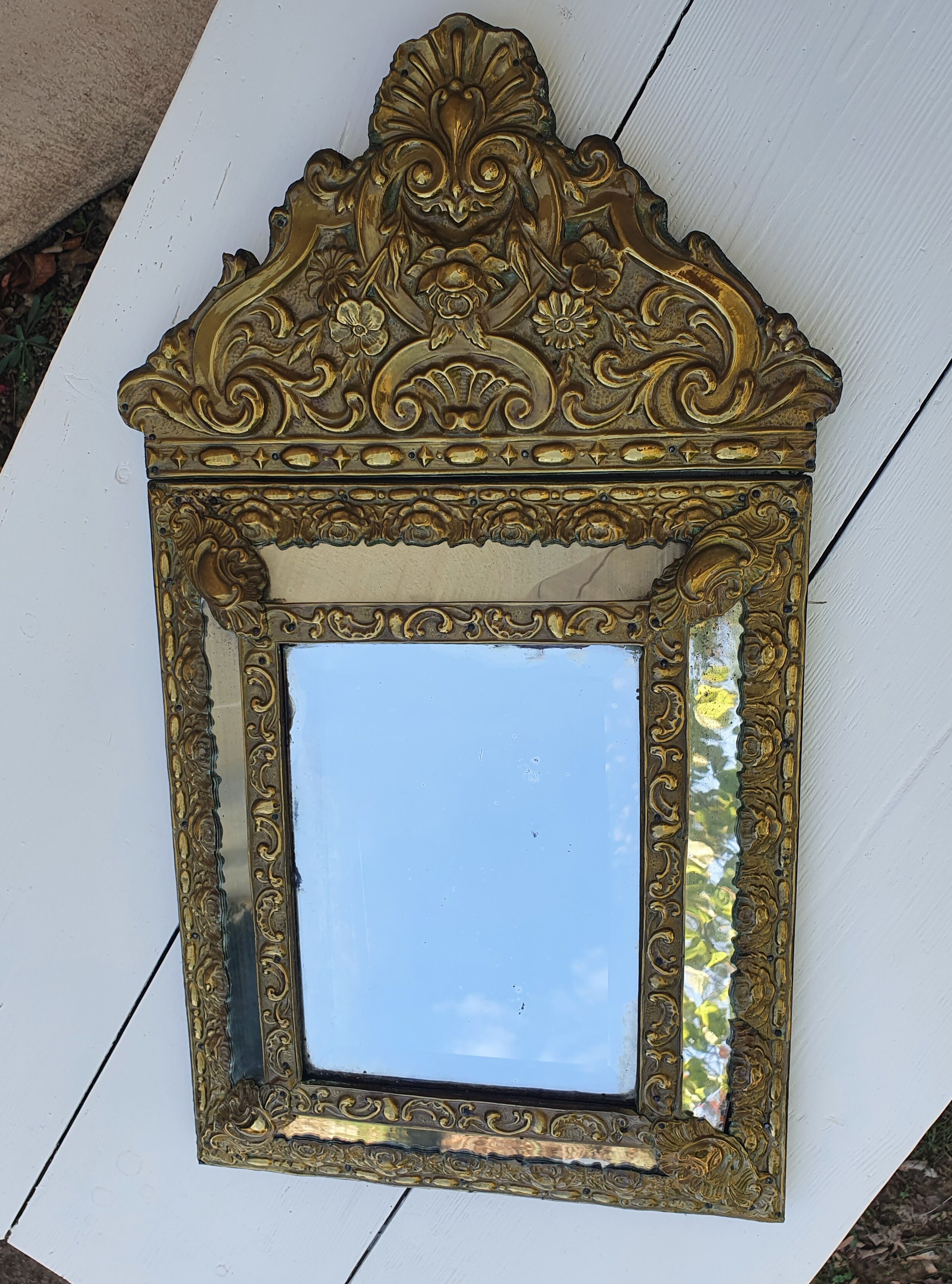 Miroir à parecloses en bois doré et métal repoussé