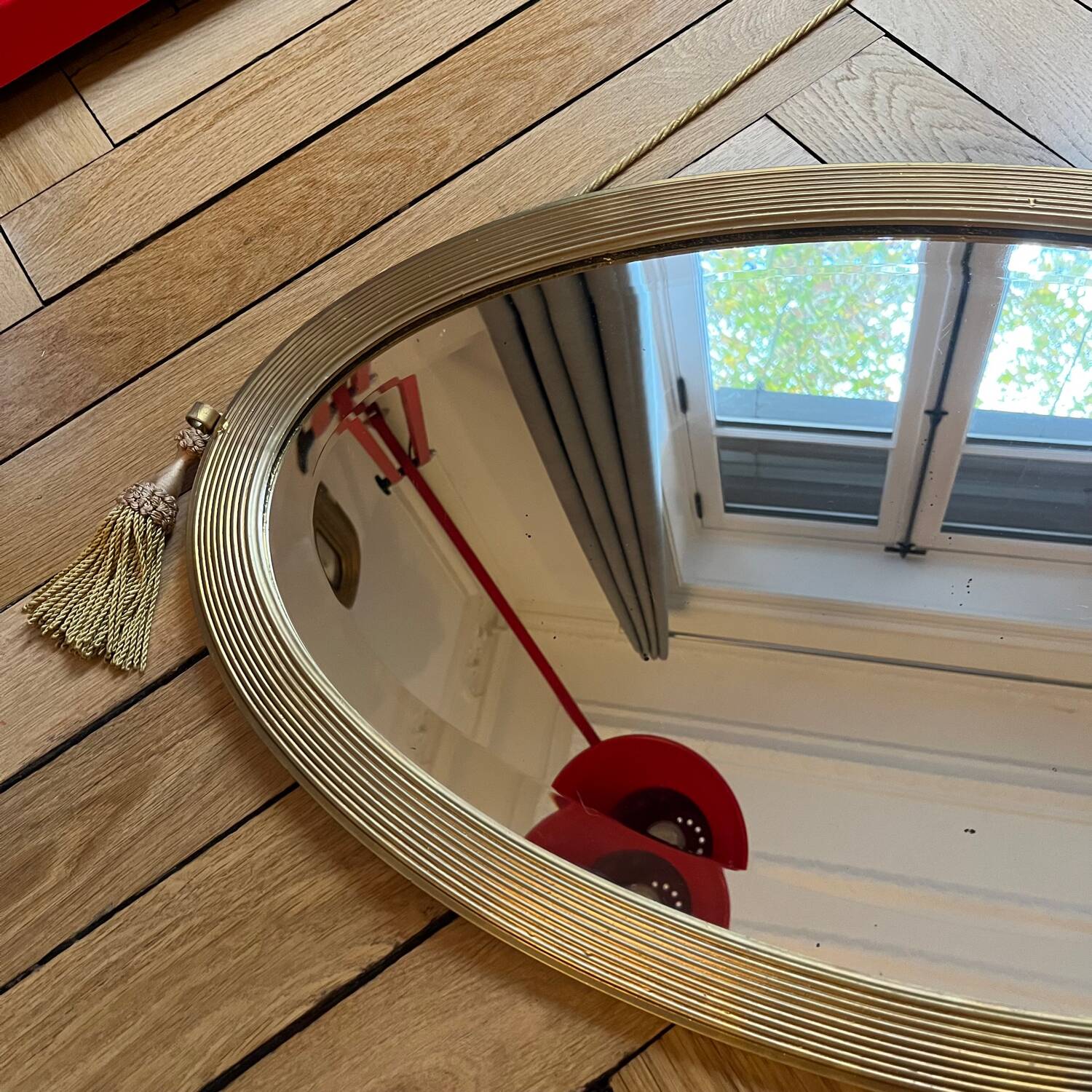 Antique oval beveled mirror adorned with tassels