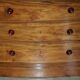 Pair of tall walnut chests of drawers with curved fronts in country style.