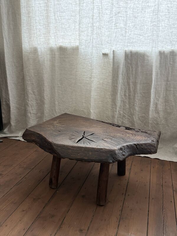 Table basse en bois massif avec une forme organique.
