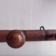 Wall-mounted coat rack with 8 turned wooden hooks in faux bamboo style.