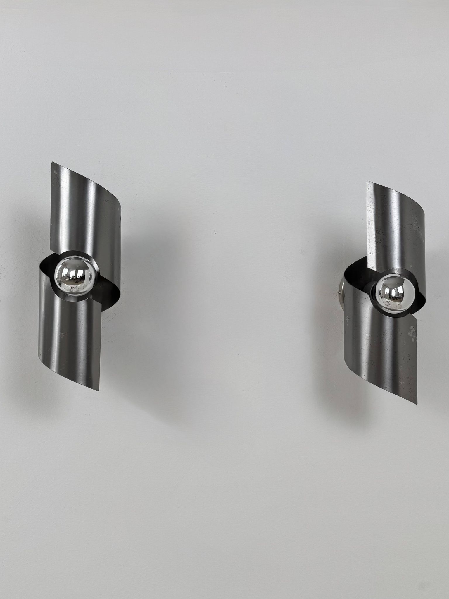 Pair of vintage wall lights, curved patinated steel, France, 1970.
