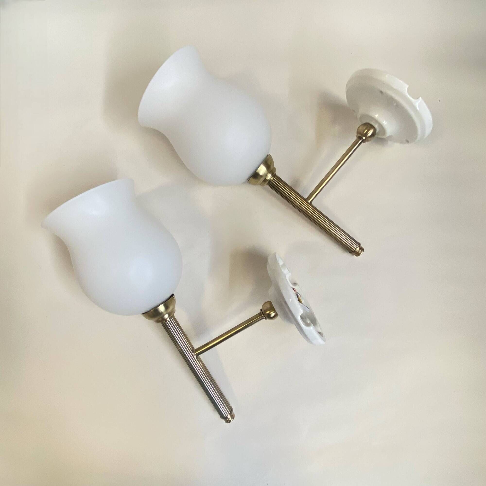 Pair of brass torch wall lights with white opal glass and porcelain