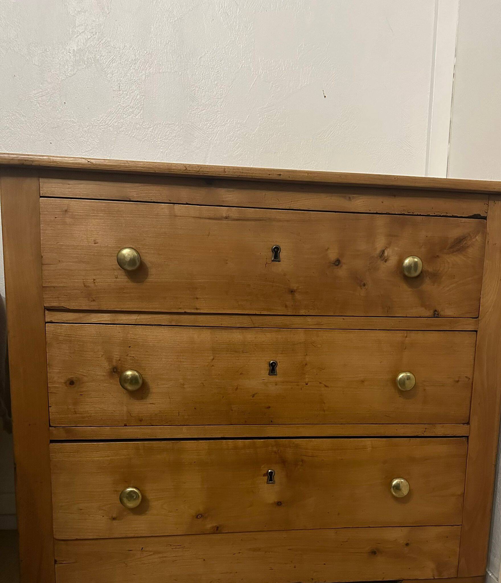 Rustic English pine chest of drawers with porcelain knobs.