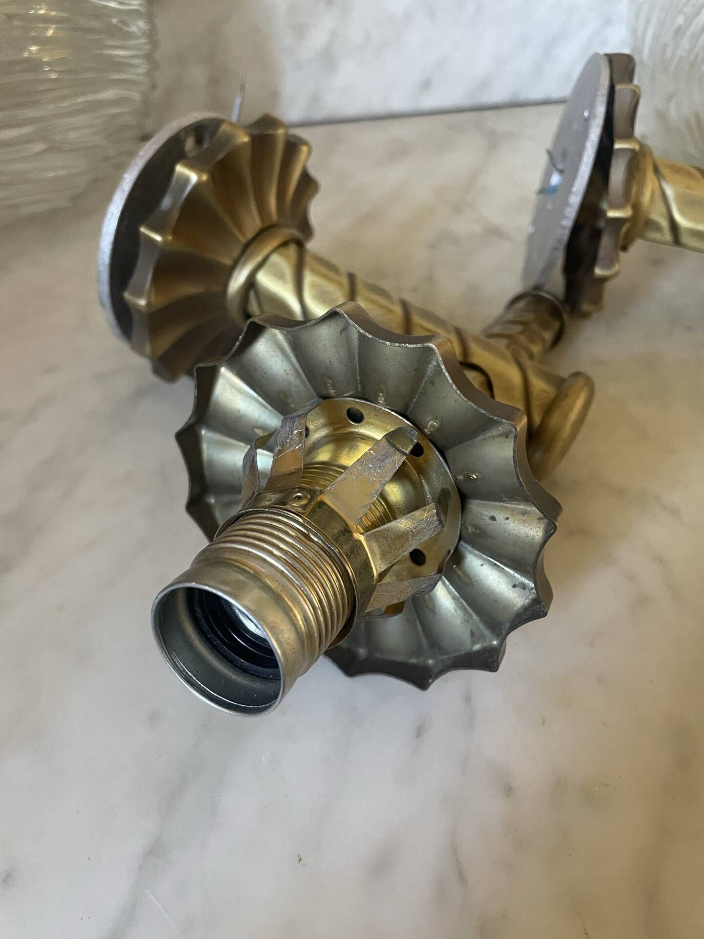 Pair of neoclassical wall sconces in twisted brass and ribbed glass.