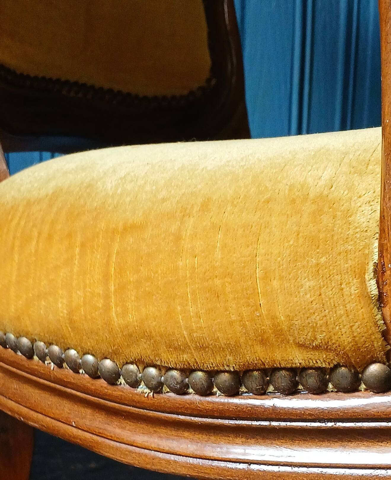 Velvet cabriolet armchair with decorative copper studs.