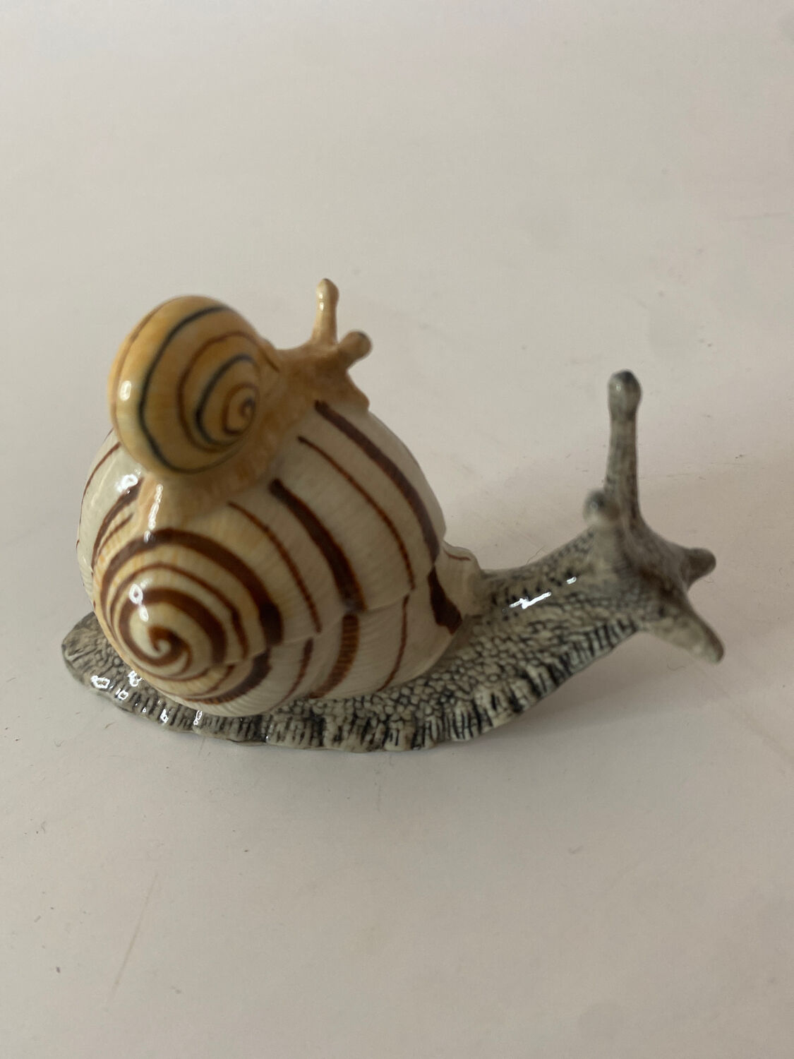Porcelain figurine snail and its small
