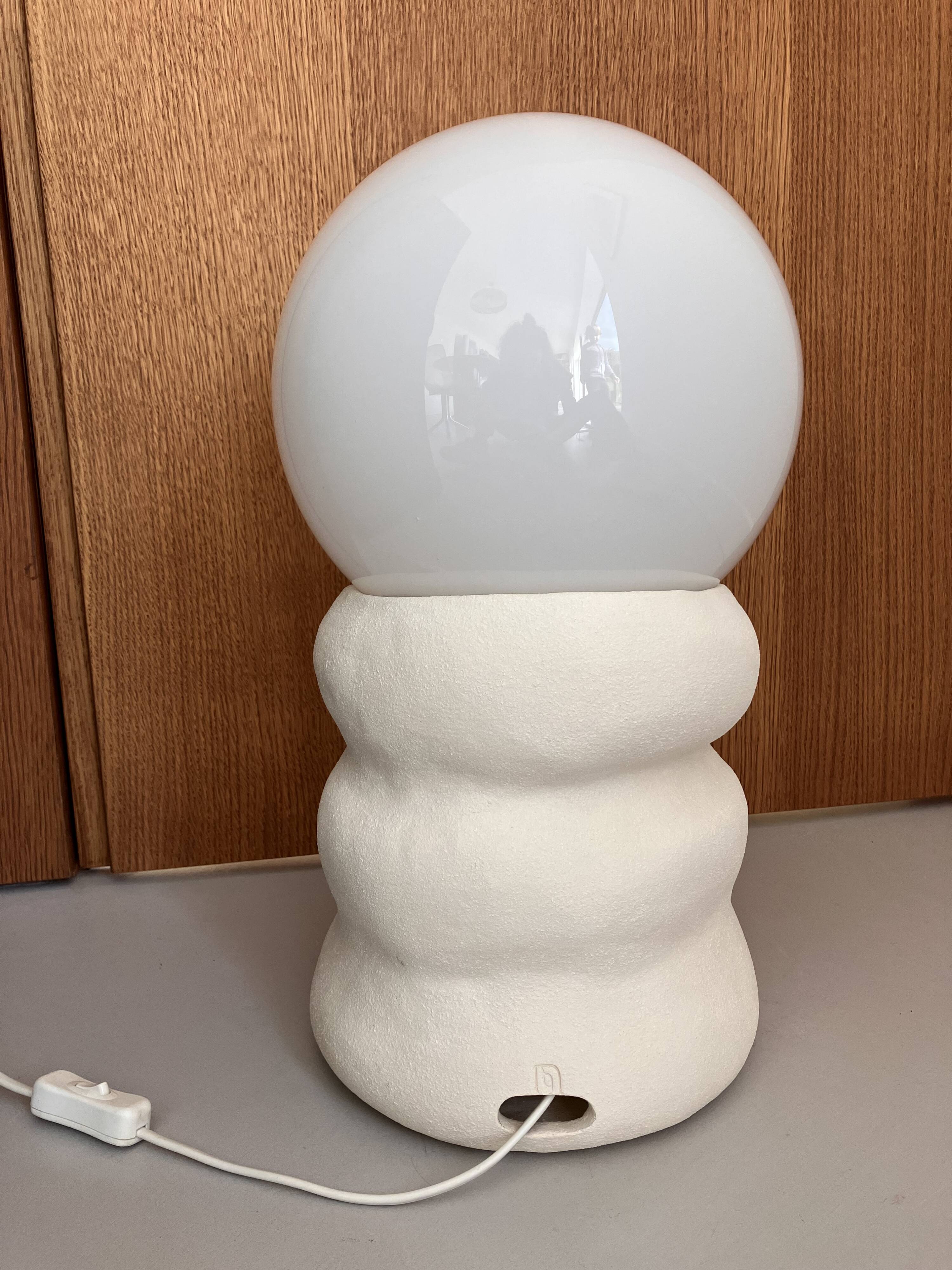 Large table lamp in off-white ceramic with an organic globe shape.